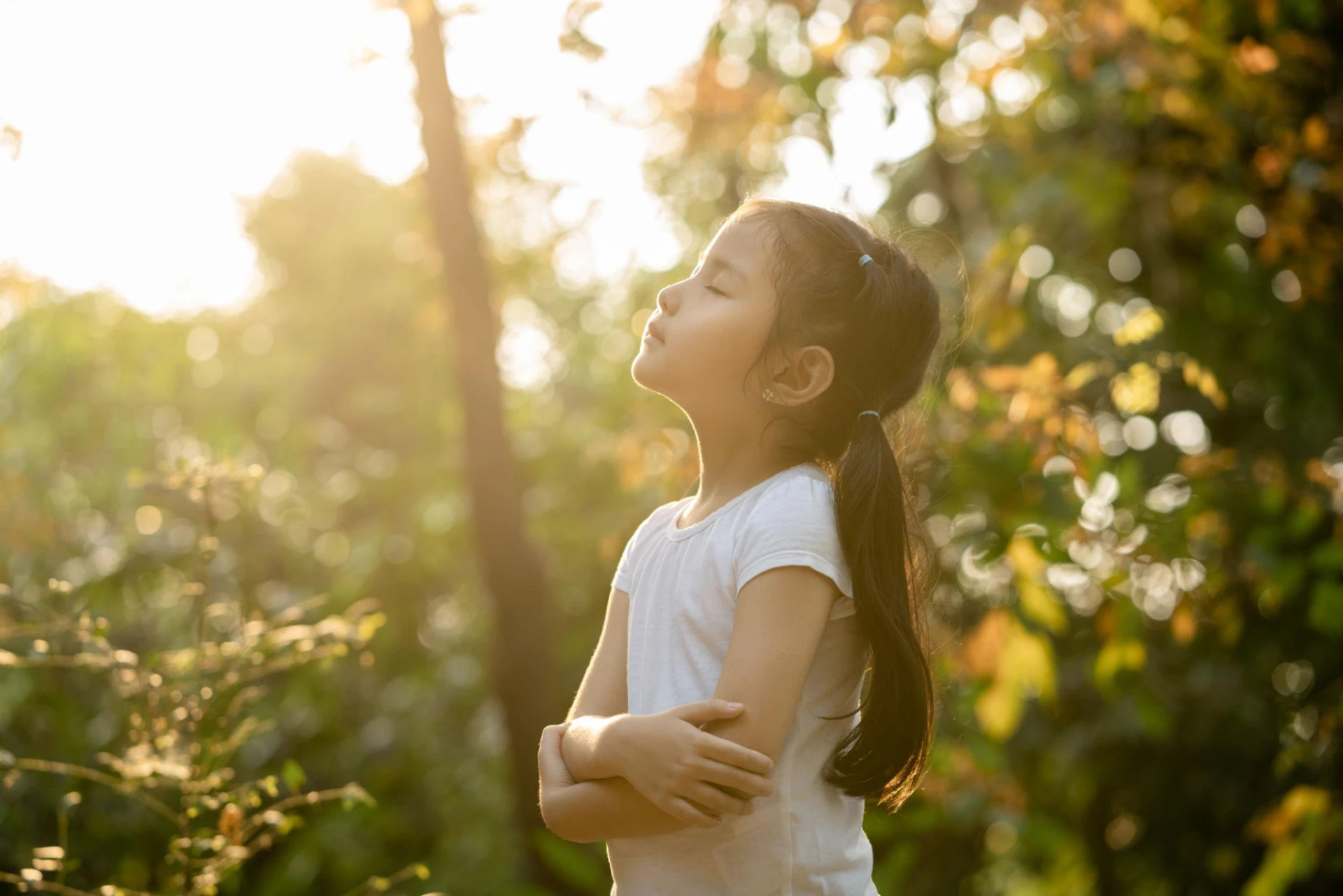 Young girl breathing calmly outdoors in golden morning light