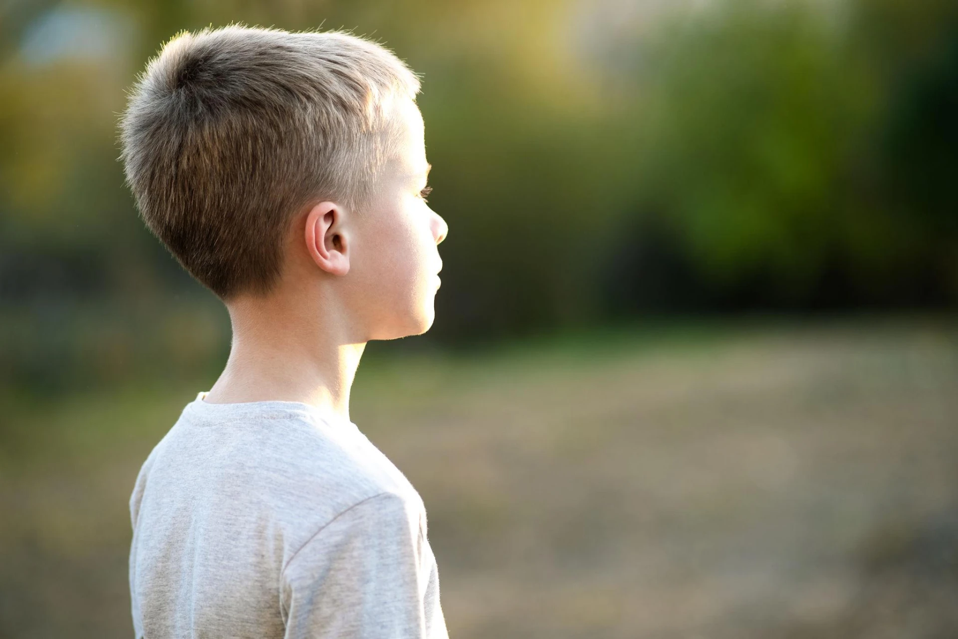 Profile view of a young child outdoors in soft natural light